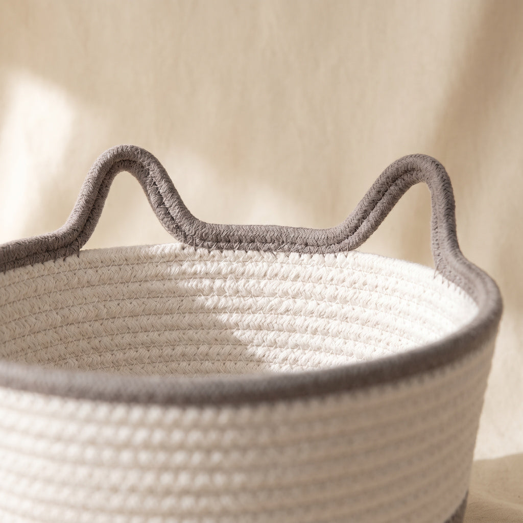 Close-up of the two cat-ear rope handles on the rim of the woven cotton bed