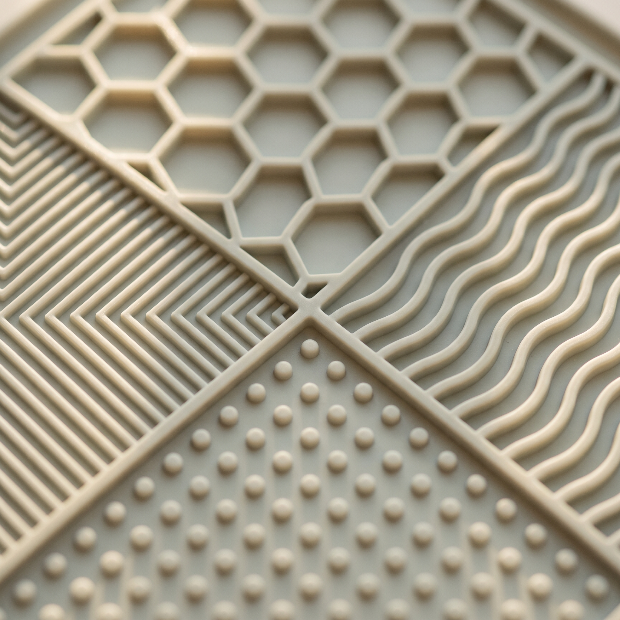 Close up of the four lick mat textures: honeycomb, cross-hatch, raised dots and wave ridges
